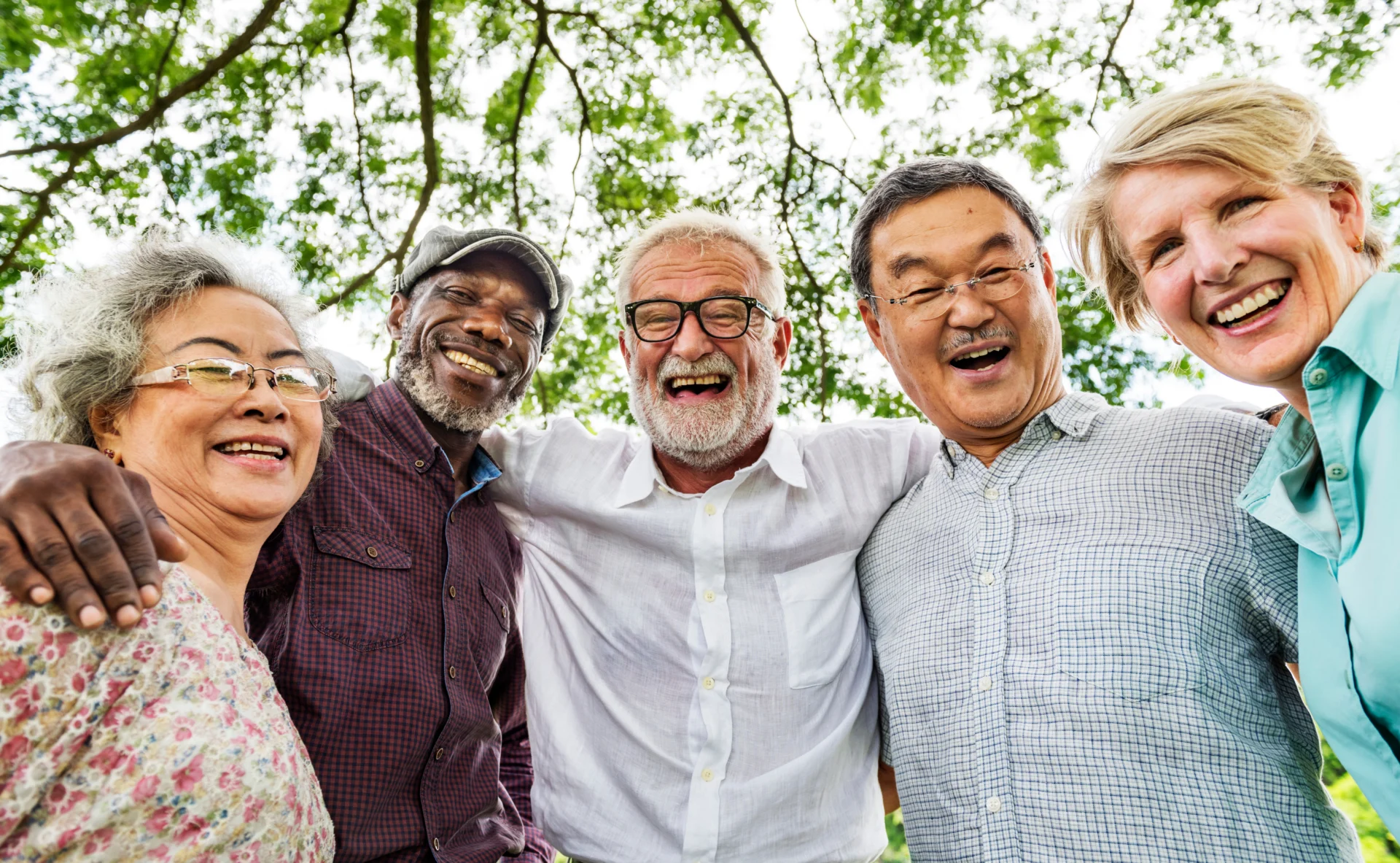A group of older friends laughing together outdoors